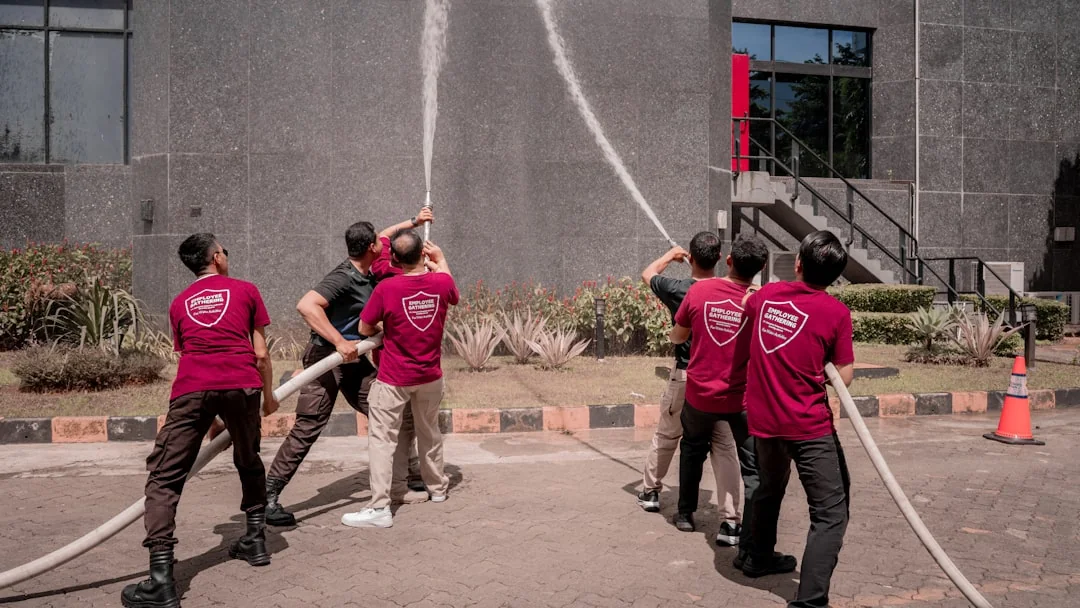 Professional workers clean skyscraper windows using ropes in urban setting.